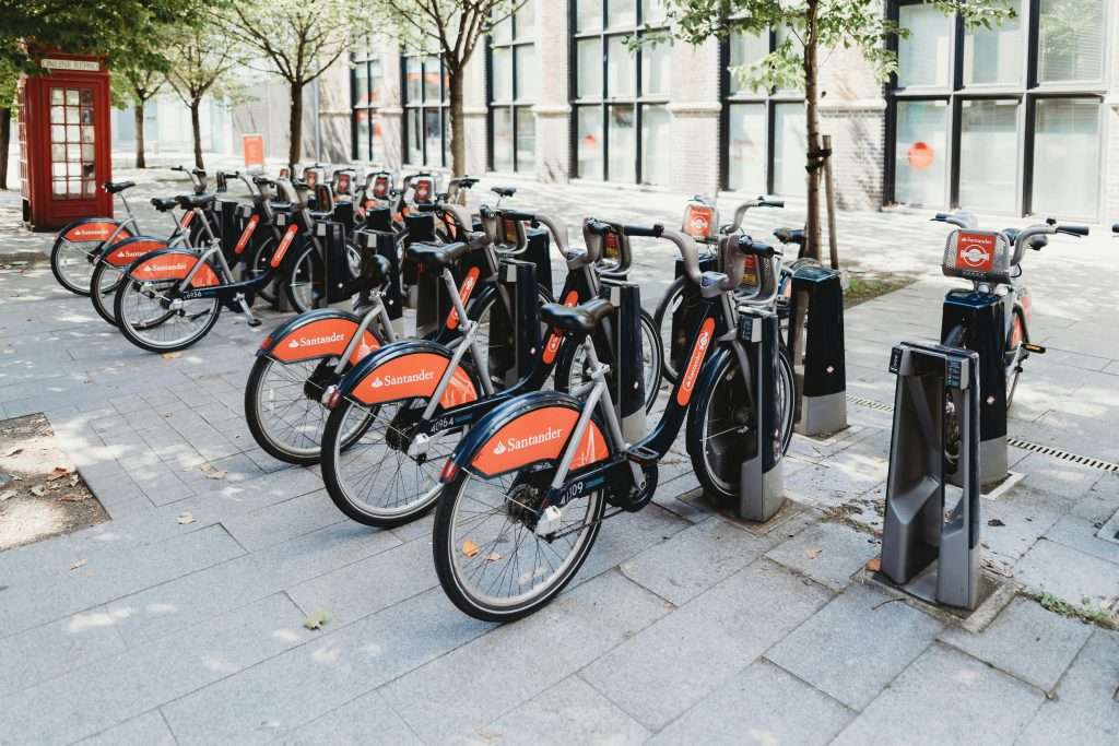 Santander Cycles, Black and Red Bikes Parked Under Trees
