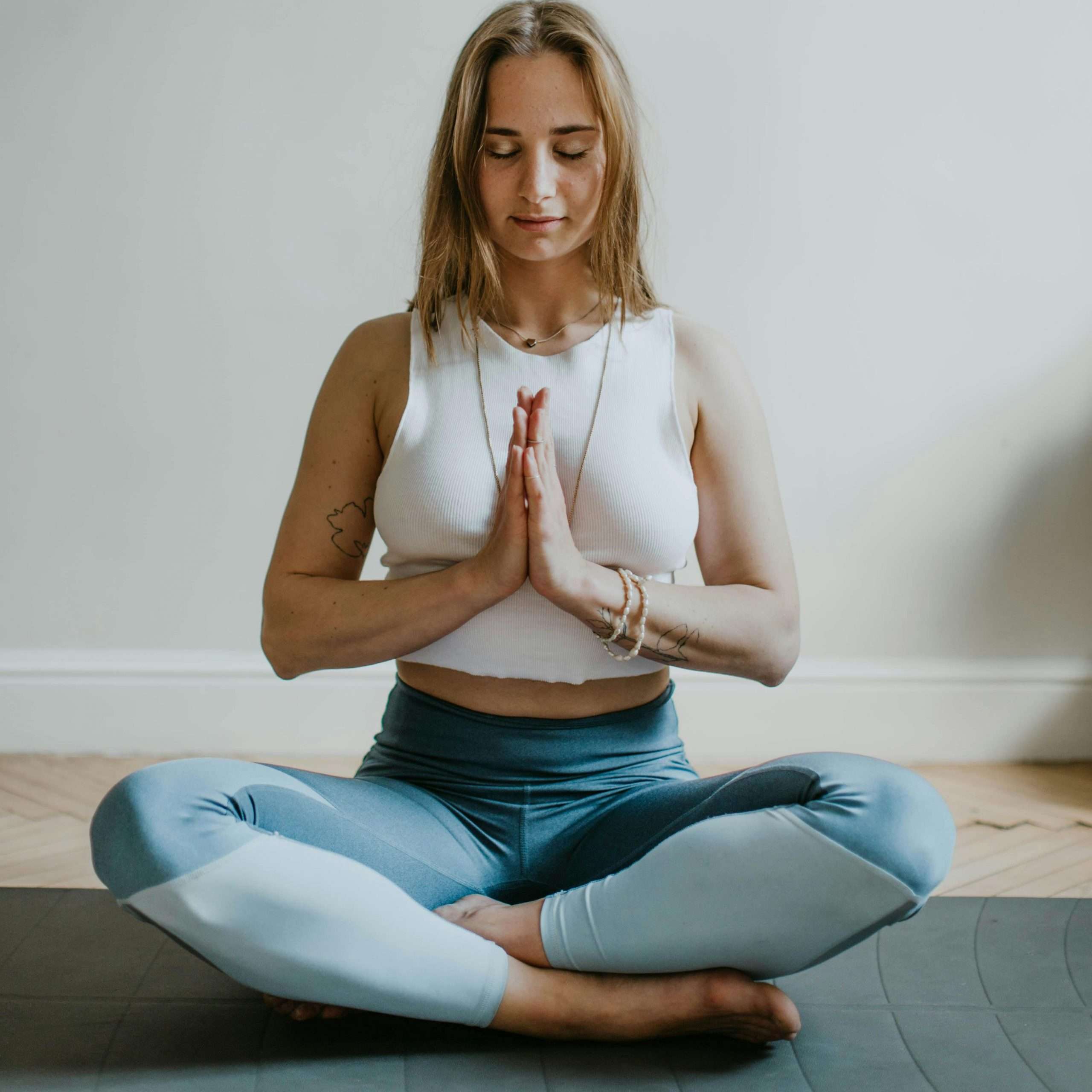 A serene image of a woman practicing meditation indoors, promoting mindfulness and wellbeing.